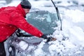 Winter problems of car drivers. Machine, covered with snow. A man brushing snow from the car. man removing snow from car