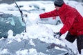 Winter problems of car drivers. A man brushing snow from the car. man removing snow from car