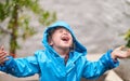 Winter, rain jacket and a girl playing in the weather outdoor alone, having fun during the cold season. Children, water Royalty Free Stock Photo