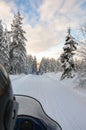 A winter ride on a snowmobiles in the forest, winter landscape and snowmobile track, Vuokatti, Finland