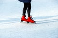 Winter rink. The girl in the red skates riding on the ice. Active family sport during the winter holidays and the cold season. Royalty Free Stock Photo