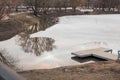 Winter river lat sunset. Water covered with ice, wooden bridge a Royalty Free Stock Photo