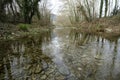 Winter river water stream with leafless wood trees landscapeWinter river water stream with leafless wood trees landscape Royalty Free Stock Photo