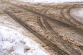 Winter road with car tracks in dirty snow and de-icing chemicals