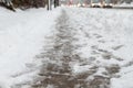 Winter road with melting from salt snow. Close up of sidewalk with slush on snowy day. Royalty Free Stock Photo