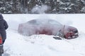 winter road. The red car skidded, it is in a ditch. Badly damaged. People are trying to help and pull out Royalty Free Stock Photo