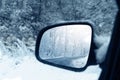 The winter road is reflected in the rear mirror of the car. Close-up Royalty Free Stock Photo