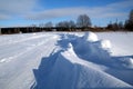 Winter road on a sunny day with snowdrifts along the edges Royalty Free Stock Photo