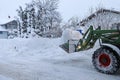 In winter the road in a village is cleared with a tractor Royalty Free Stock Photo