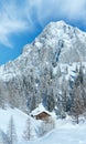 Winter rock with fresh fallen snow on top and house Royalty Free Stock Photo