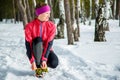 Winter runner getting ready running tying shoe laces. Beautiful fitness model training outside. Copy space on snow. Royalty Free Stock Photo