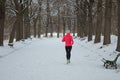 Winter running in park: happy active woman runner jogging in snow, outdoor sport and fitness Royalty Free Stock Photo