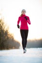 Winter running - Young woman running outdoors Royalty Free Stock Photo