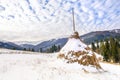 Winter rural landscape, haystacks on the background of snow-capped mountains and forestÃÂ±, Transcarpathia, Ukraine