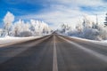 Winter rural landscape with the road the forest and the blue sk Royalty Free Stock Photo