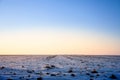 Winter rural landscape, a snowy agricultural field covered with snow and ice, at sunset, in the Banat region of Vojvodina, Serbia