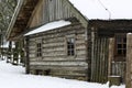 Winter Russian landscape. An old wooden hut, a log house with a thatched roof. Village covered in snow. house with barn. Royalty Free Stock Photo