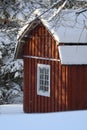 Fresh snow giving a mantle to a beautiful playhouse and trees in the garden