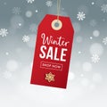 Winter sale poster template. Hanging red gift tag, label with gingerbread cookie, falling snowflakes bokeh lights and Royalty Free Stock Photo