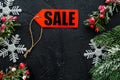Winter sale. Word sale on red label near xmas toys and spruce branch on black background top view copyspace Royalty Free Stock Photo