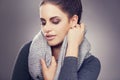 Winter, scarf and face of woman for beauty, fashion and clothes with makeup  on gray background. Female person Royalty Free Stock Photo