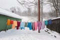 winter scene with colorful clothes drying against white snow