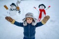 Winter scene with happy child on white snow background. Enjoying nature wintertime. Happy winter time. Snowman. Winter