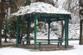 Winter scene in a park: a gazebo covered of snow