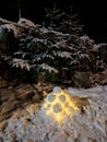 Scene with snow, pines, and snow lantern in the dark, Lapland