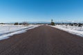 Winter scene from a straight road through a great plain landscape