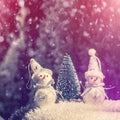 Winter scenery. Christmas snowmans and Christmas tree on natural snow in holiday evening. winter snowcowered trees at the