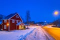 Winter scenery with red wooden house at night