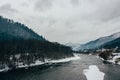 Winter scenery of river in the mountains and forest. Cloudy grey sky Royalty Free Stock Photo
