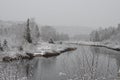 Winter Scenery Season Photo and Image. Horizontal Photo. Displaying its white blanket on trees, river and with a grey sky with a