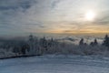 Winter scenery with snow covered road, frozen trees, invesion clouds and blue sky above on Lysa hora hill in Moravskoslezske Royalty Free Stock Photo