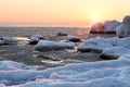 Winter sea in the early morning. frozen water and stones at dawn. Royalty Free Stock Photo