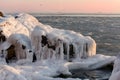 Winter sea in the early morning. frozen water and stones at dawn.