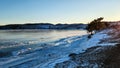 Winter sea sunset. Panoramic view of the snow-covered shore of the frozen sea, the lake at sunset. Shards of ice close-up. Christ Royalty Free Stock Photo