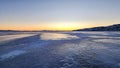 Winter sea sunset. Panoramic view of the snow-covered shore of the frozen sea, the lake at sunset. Shards of ice close-up. Royalty Free Stock Photo