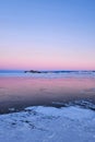 Winter sea sunset. Panoramic view of the snow-covered shore of the frozen sea, the lake at sunset. Shards of ice close-up. Royalty Free Stock Photo