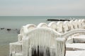 Winter seascape, frozen arch fence with huge icicles