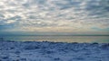 Seascape, slow freezing sea, glorious skies, white pieces of ice by the sea