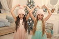 Winter season accessory. Children wear knitted hats. Girls long hair happy smiling faces christmas tree background. Kids