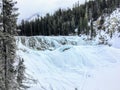A winter setting of a frozen waterfall surrounded by forests and mountains at wapta falls, yoho national park, british columbia Royalty Free Stock Photo