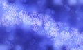 Winter shiny snowflakes blurred background in light blue white colors. Blurry Christmas holiday background with snow flakes