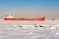 Winter shipping. Big cargo ship in frozen ice sea Royalty Free Stock Photo