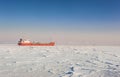 Winter shipping. Big cargo ship in frozen sea fairway Royalty Free Stock Photo