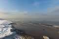 Winter shoreline of baltic sea with snow and ice under blue sky with light clouds, selective focus