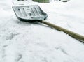 Winter shovel for snow removal outside. The shovel lies on the snow. Tool for cleaning the yard from snow.