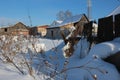 Winter in Siberia village houses in snow with dry grass Royalty Free Stock Photo